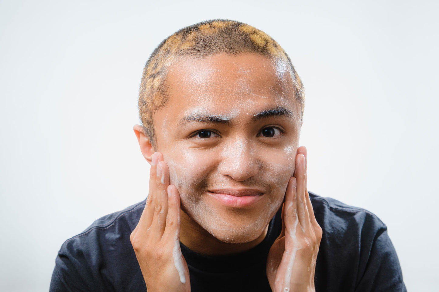 Young asian man talent model using Tyr Skincare facial cleanser, close up angle straight on
